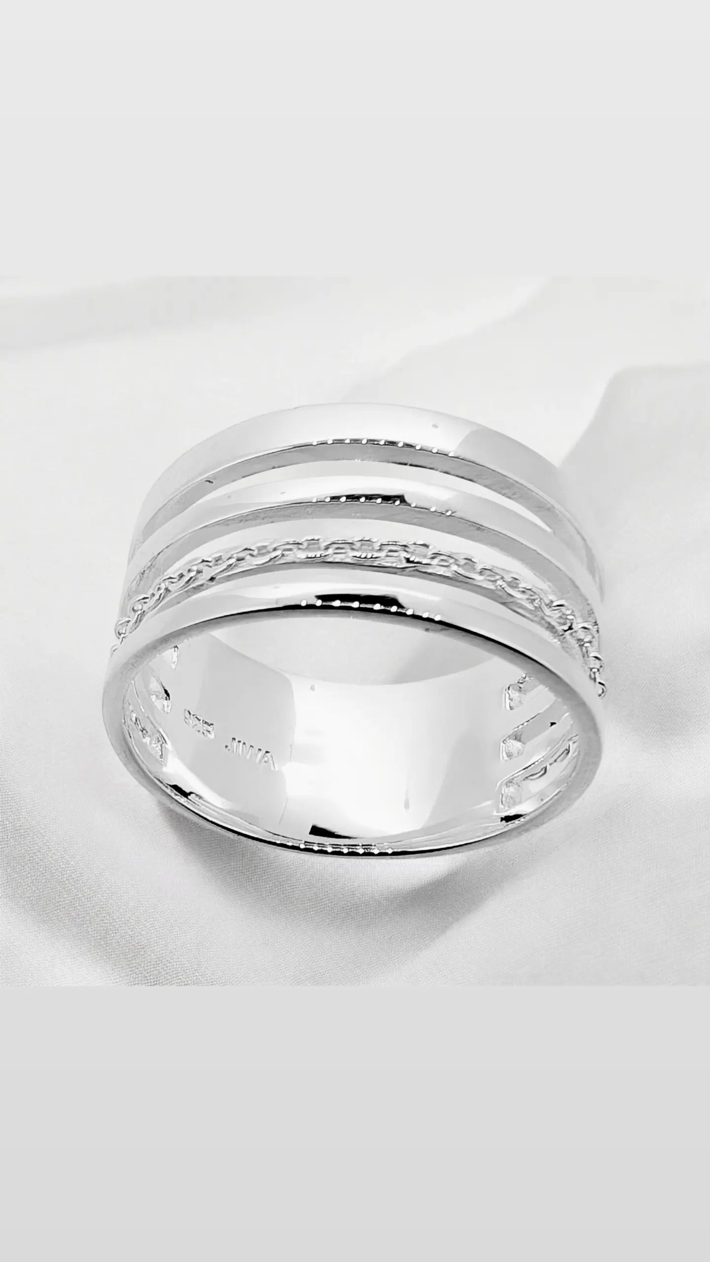 This ring features four slender strands of sterling silver with one of them intricately carved for added detail