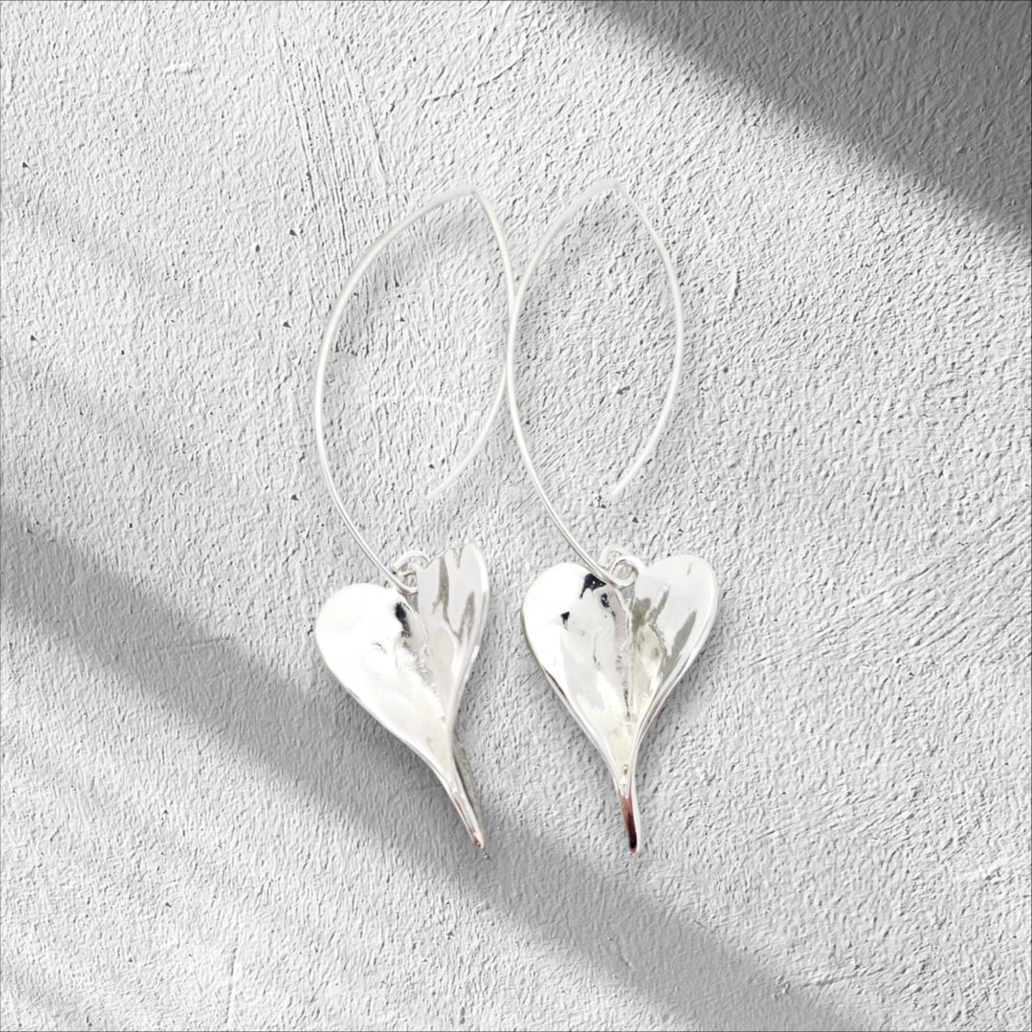 Slender stem delicately extends into a tulip-shaped sterling silver drop earring