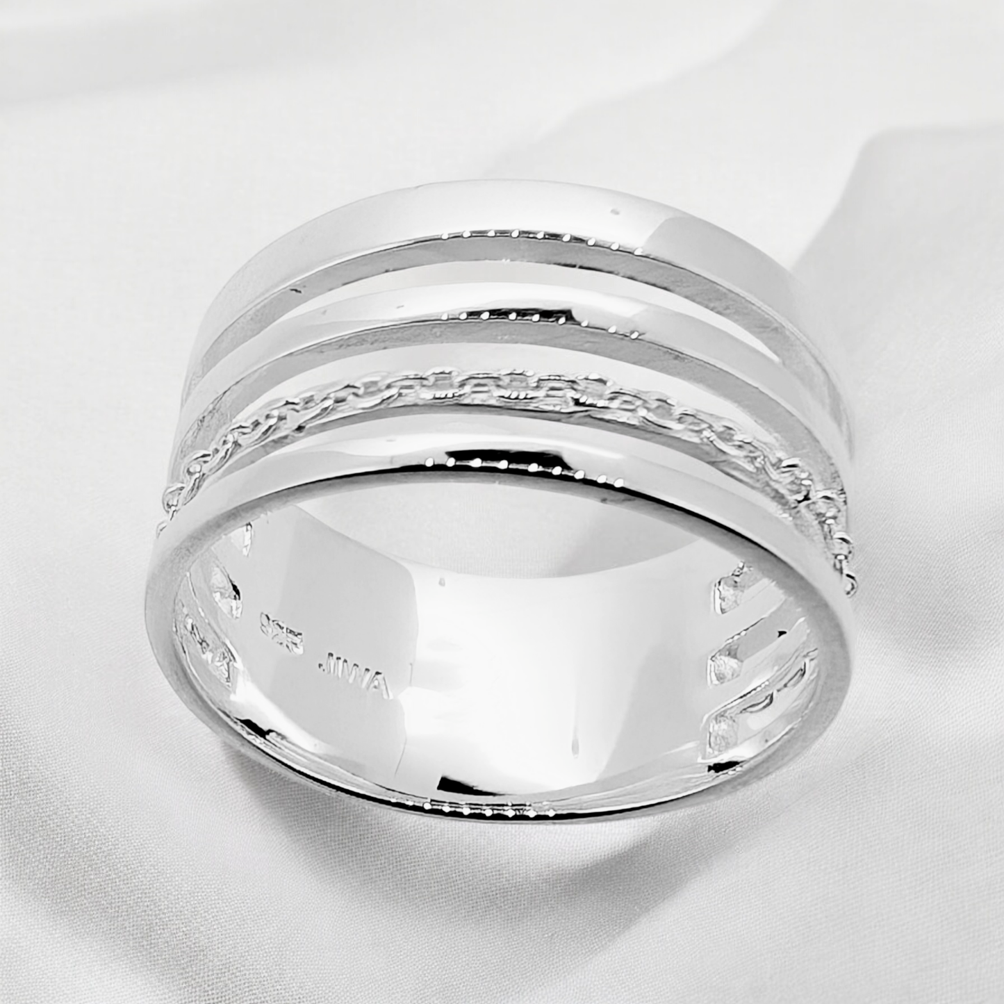 This ring features four slender strands of sterling silver with one of them intricately carved for added detail