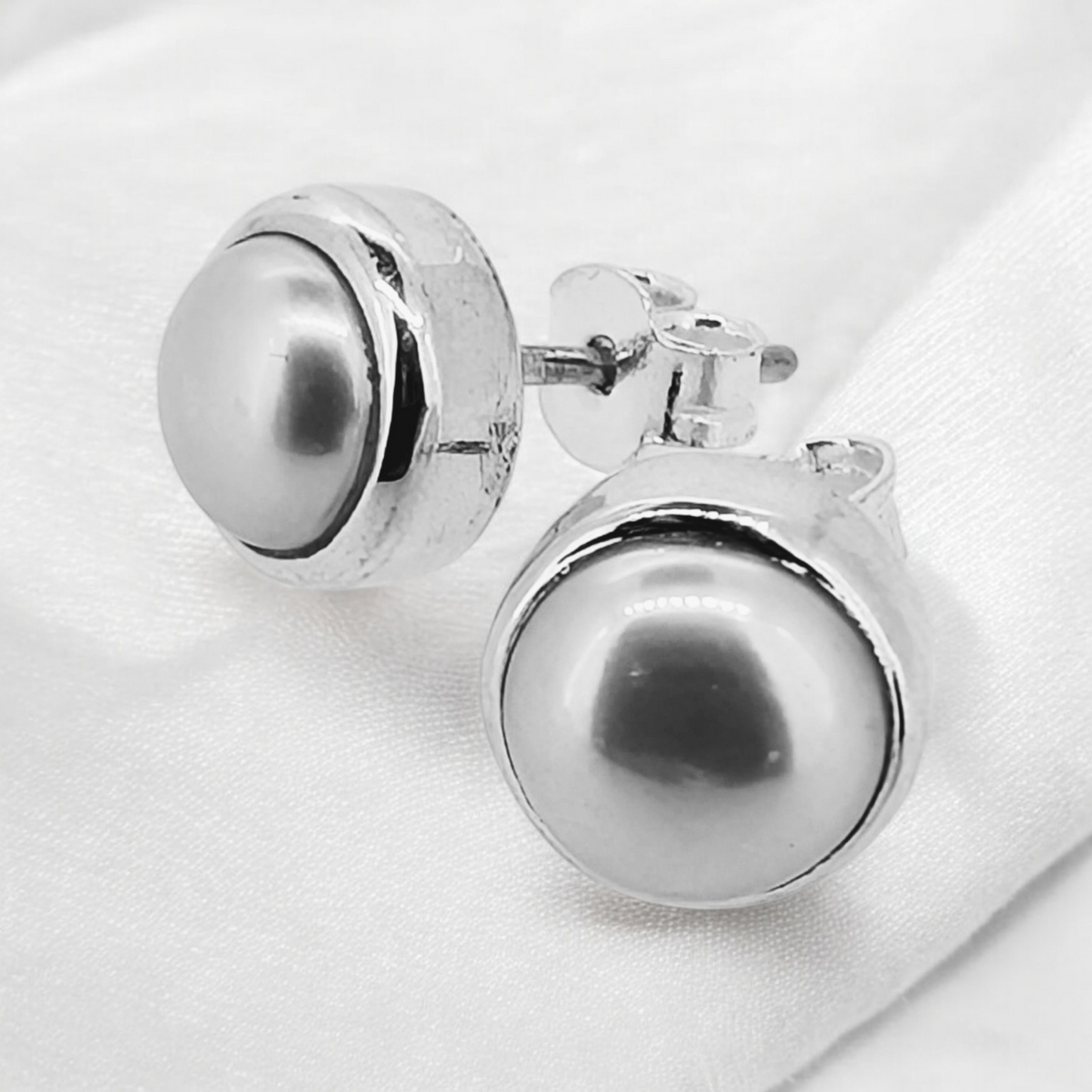 A simple South Sea pearl bevelled sterling silver stud features a polished, lustrous South Sea pearl set in a sleek, bevelled sterling silver round frame.