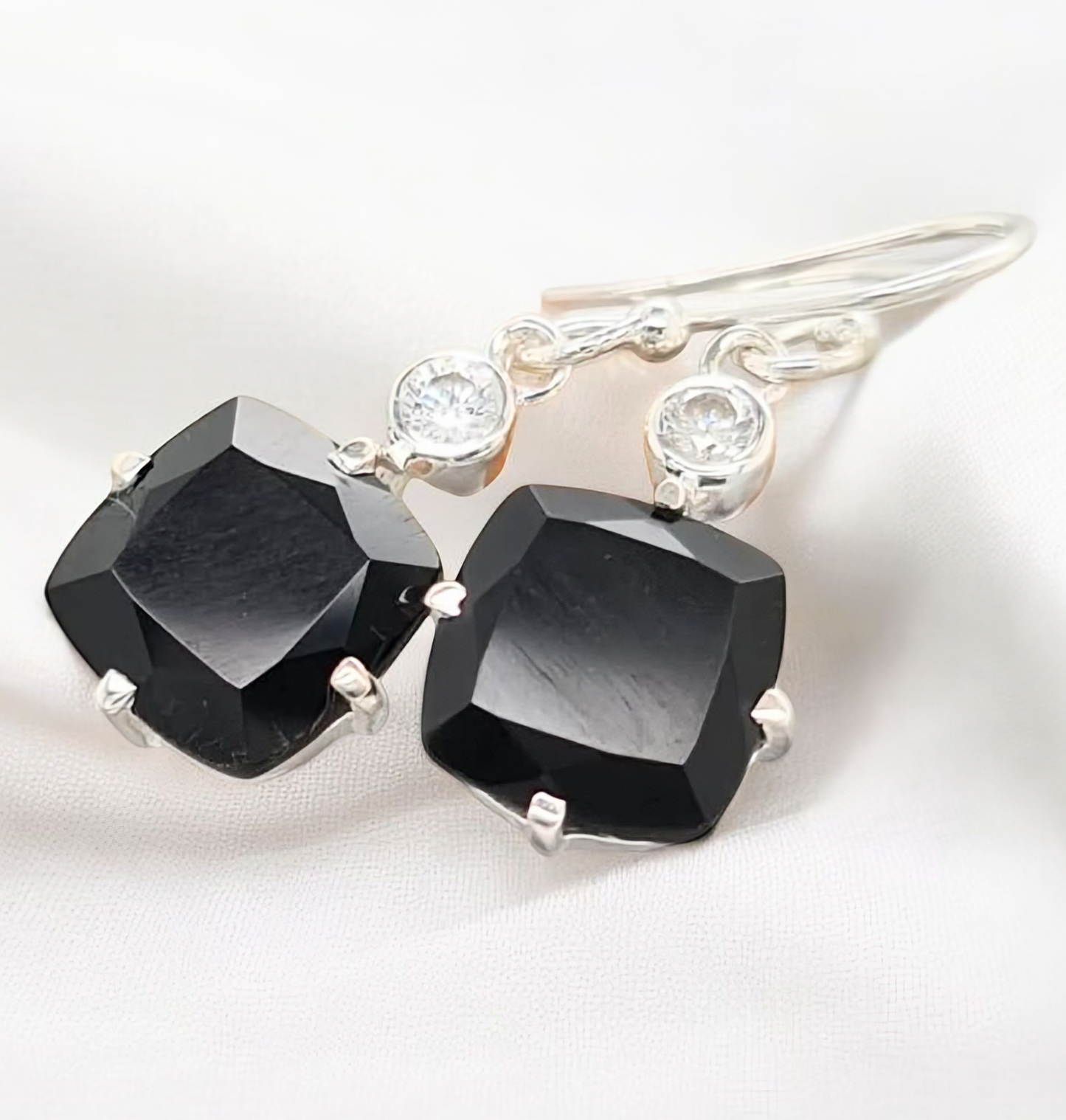 Striking sterling silver drop earrings featuring glossy black onyx stones as the focal point