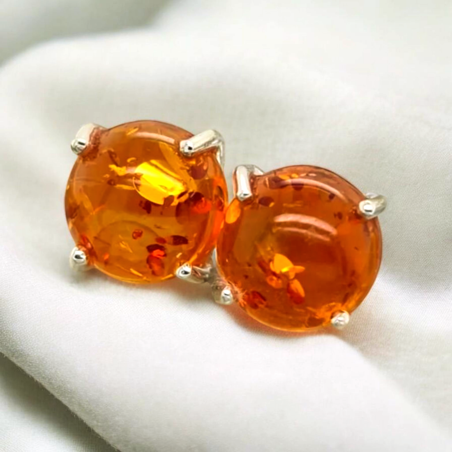 Amber Smooth Gems in claw stud earrings. The amber is a natural resin that has solidified over millions of years, often encapsulating ancient inclusions like air bubbles or small plant material