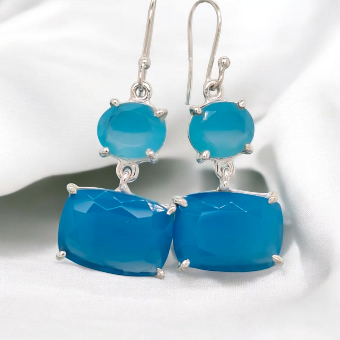 These earrings feature 2 generously sized pieces of blue chalcedony gemstones in a sterling silver claw setting.