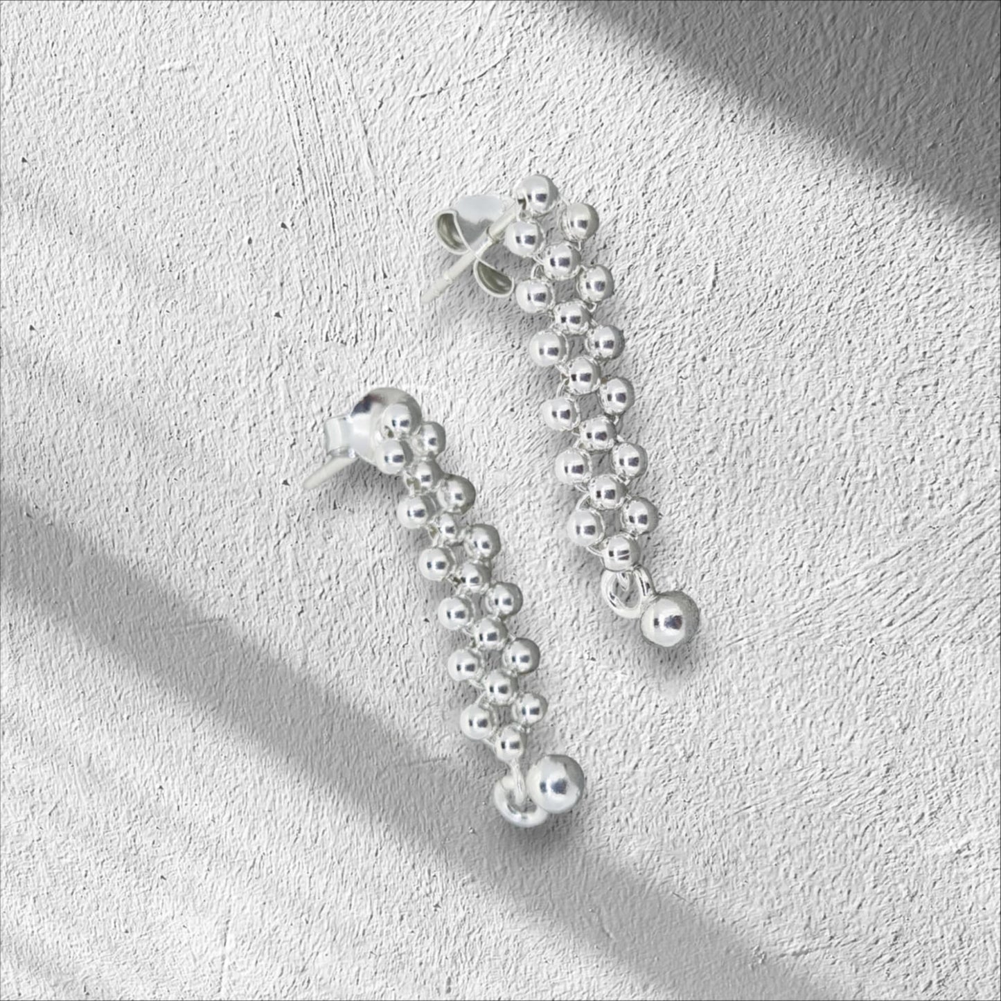 Sterling silver drop stud earrings, adorned with petite balls that sway with every movement.