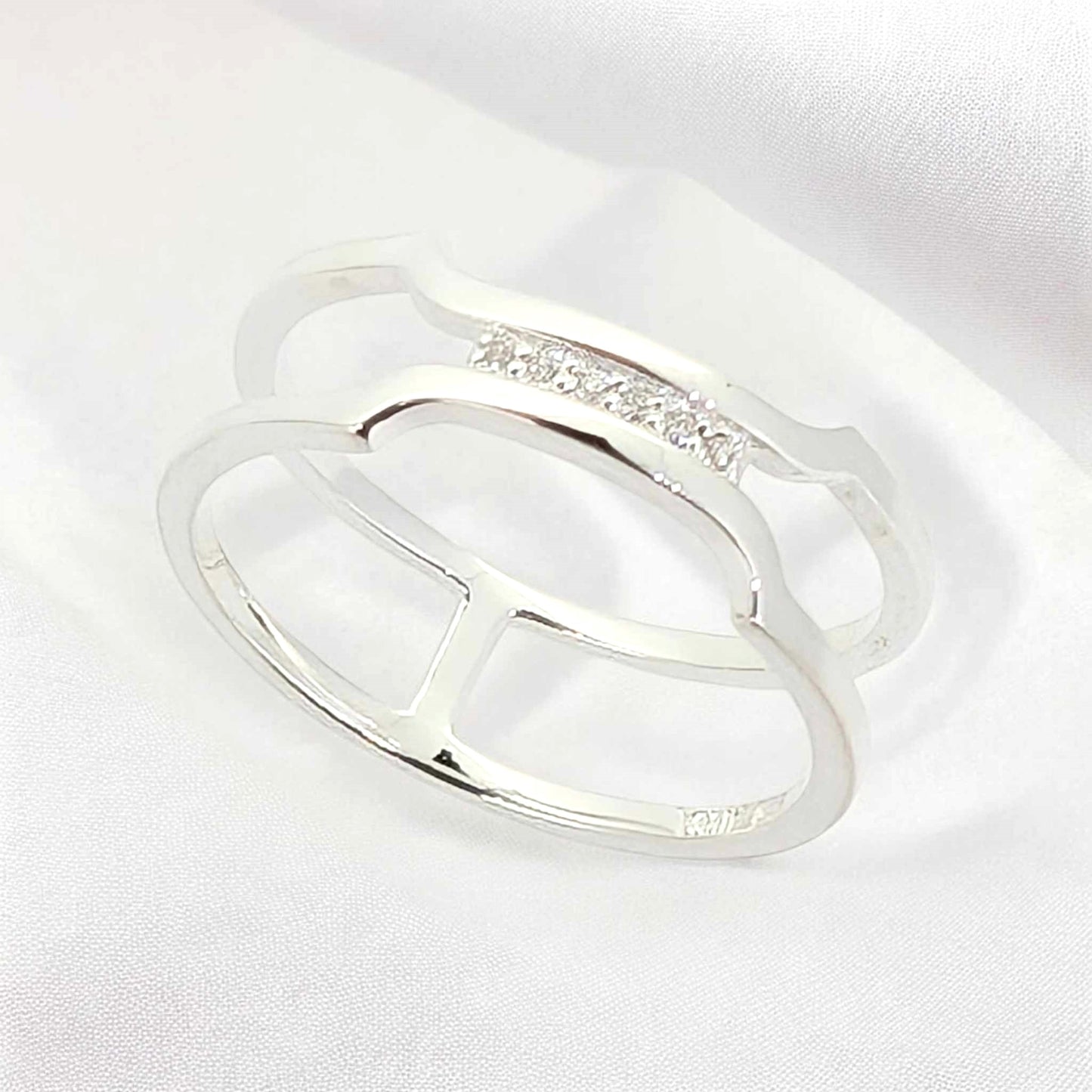 Sleek design sterling silver band ring with a delicate cluster of petite white zirconia stones joining gracefully together at the top.